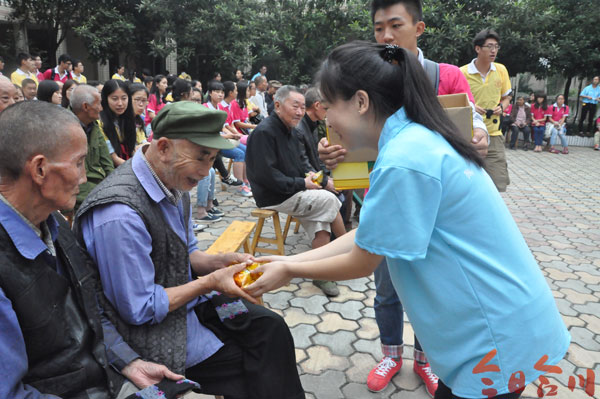 图为学生向老人们派发小礼物 记者 涂文婷 摄